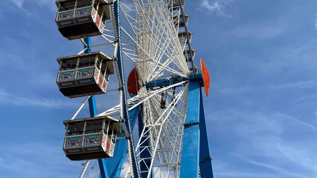 Zu sehen ist ein Tel des Riesenrads auf dem Oktoberfest – Blickwinkel ist von unten.