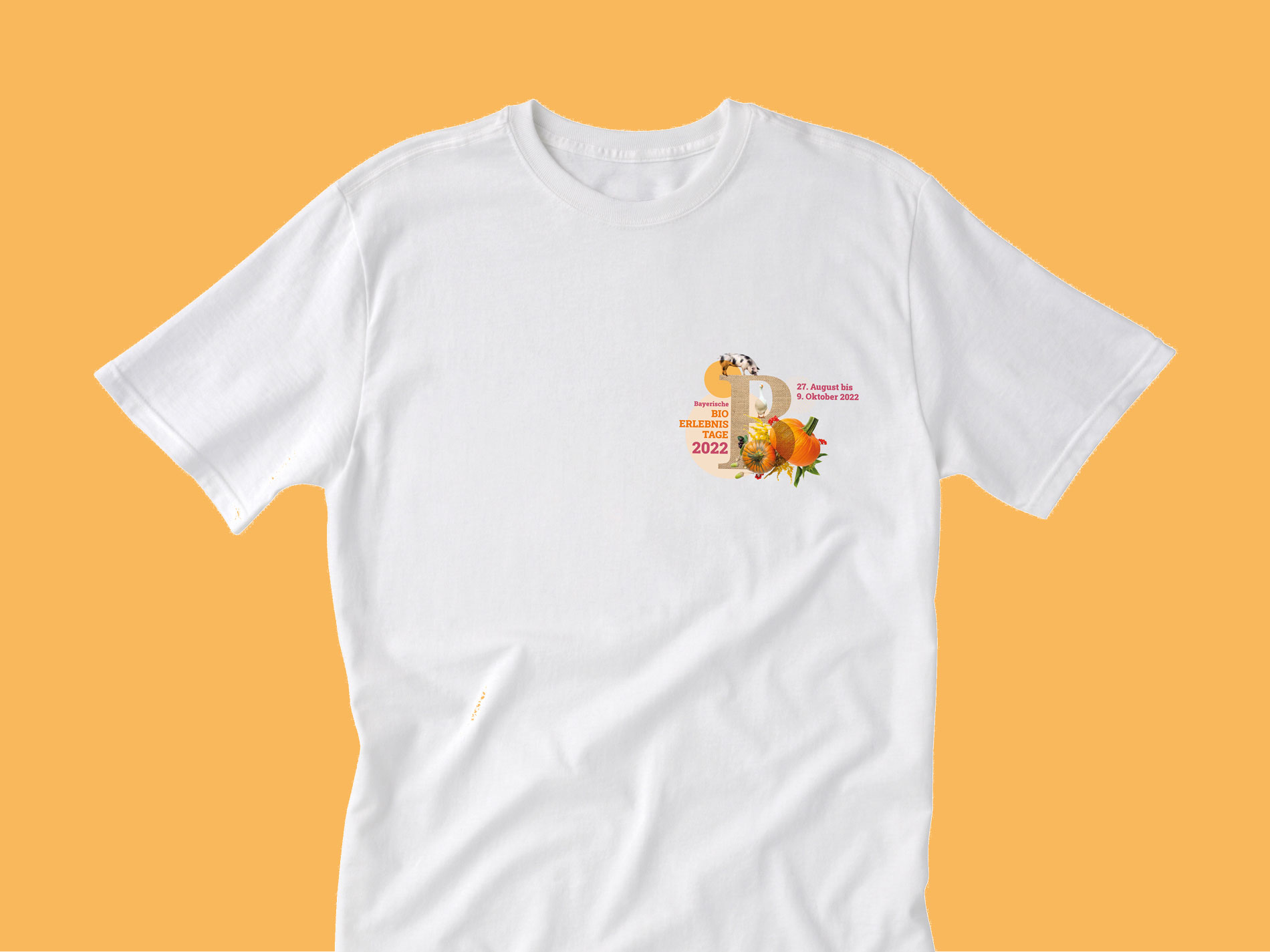 Das Bild zeigt ein weißes T-Shirt mit einem Logo und einem Design für die "Bio Erlebnistage 2022", das auf der linken Brustseite platziert ist.