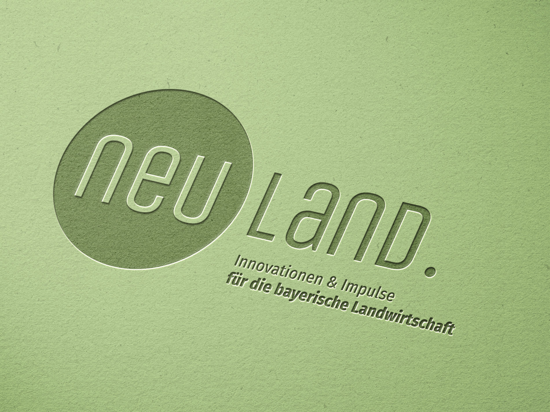 Zu sehen st das Neuland Logo auf grünem Papier.