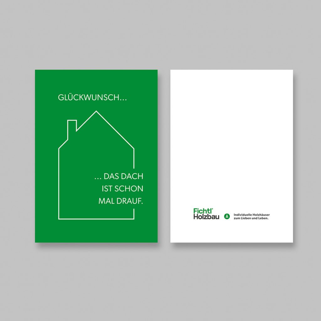 Postkarte von Holzbau Fichtl mit der Headline „Glückwunsch … das Dach ist schon mal drauf." und stilisierter Hauskontur auf grünem Grund, daneben die Rückseite mit Logo und Claim „Individuelle Holzhäuser zum Lieben und Leben".